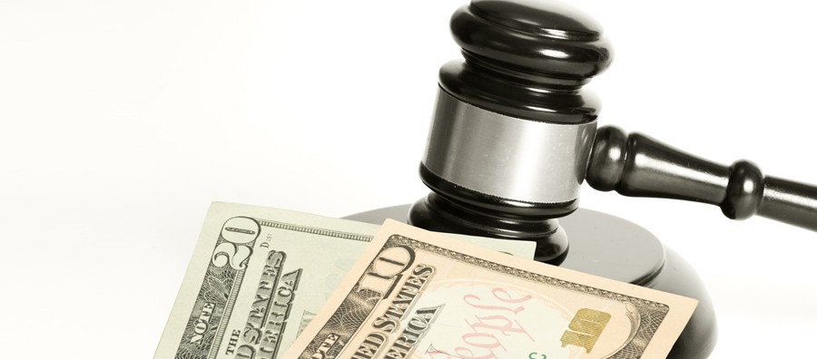 Judge's gavel resting on U.S. dollar bills, symbolizing legal and financial matters.