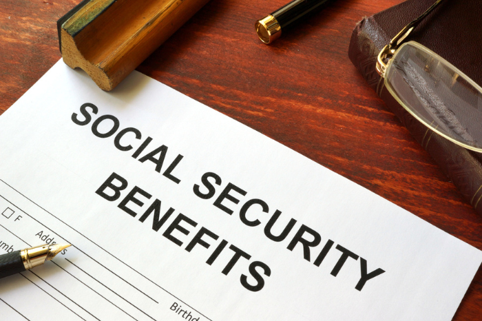 Social security benefits form, book and glasses; December 2023 Brings an Early COLA Boost for SSI Beneficiaries