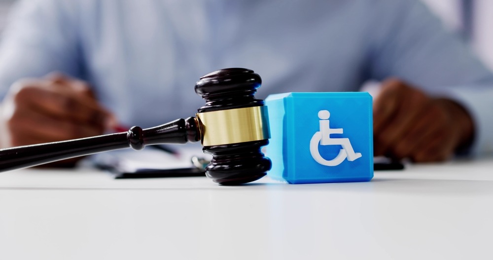 Gavel next to disability symbol block on legal desk