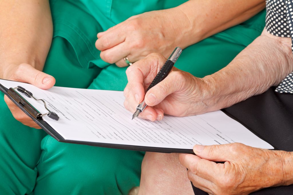 Disability lawyer and client reviewing medical documents related to SSDI claim for a commonly approved condition such as a spinal injury or severe mental disorder.