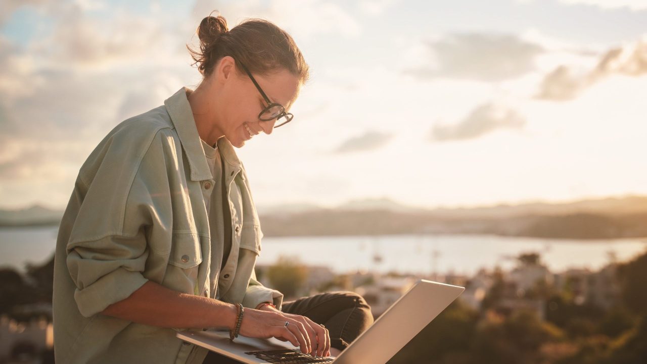 Woman on apartment balcony reviewing SSA work-related guidelines on laptop
