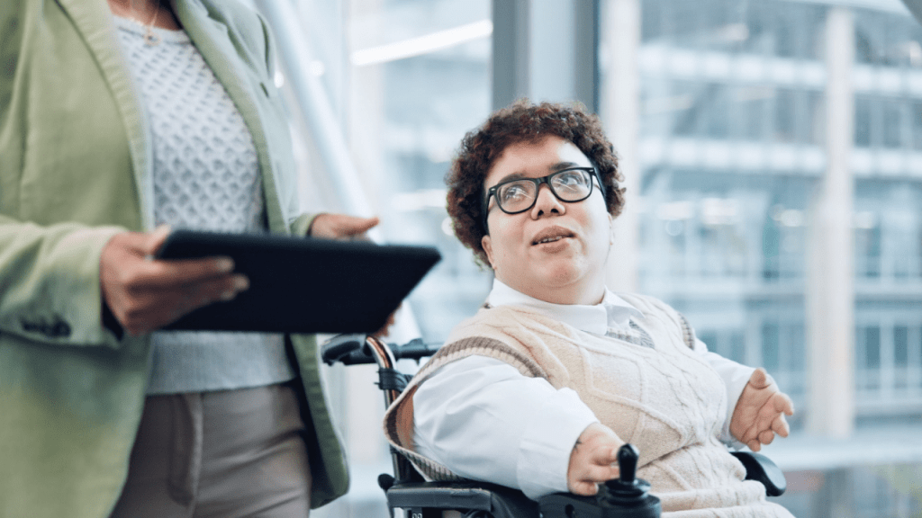 Person in motorized wheelchair speaking with advisor — is it harder to get SSI or SSDI?