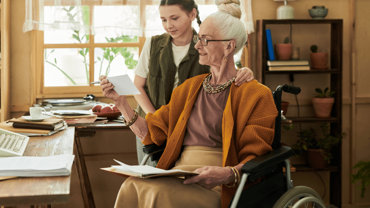 Senior woman in wheelchair reviewing Social Security documents with caregiver to learn how to get $3000 a month from Social Security