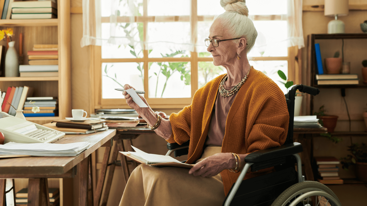 Senior woman in wheelchair reviewing documents about what is the $1800 Social Security check at her home office