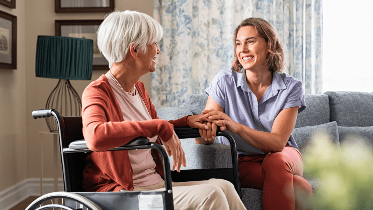 Senior woman in wheelchair with caregiver discussing what is the $943 Social Security payment in a home setting