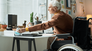 Senior woman in wheelchair reviewing paperwork on what other benefits can I get with SSDI in home office