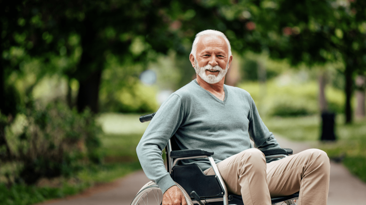 Senior man in wheelchair smiling outdoors representing what is the highest Social Security check you can get per month