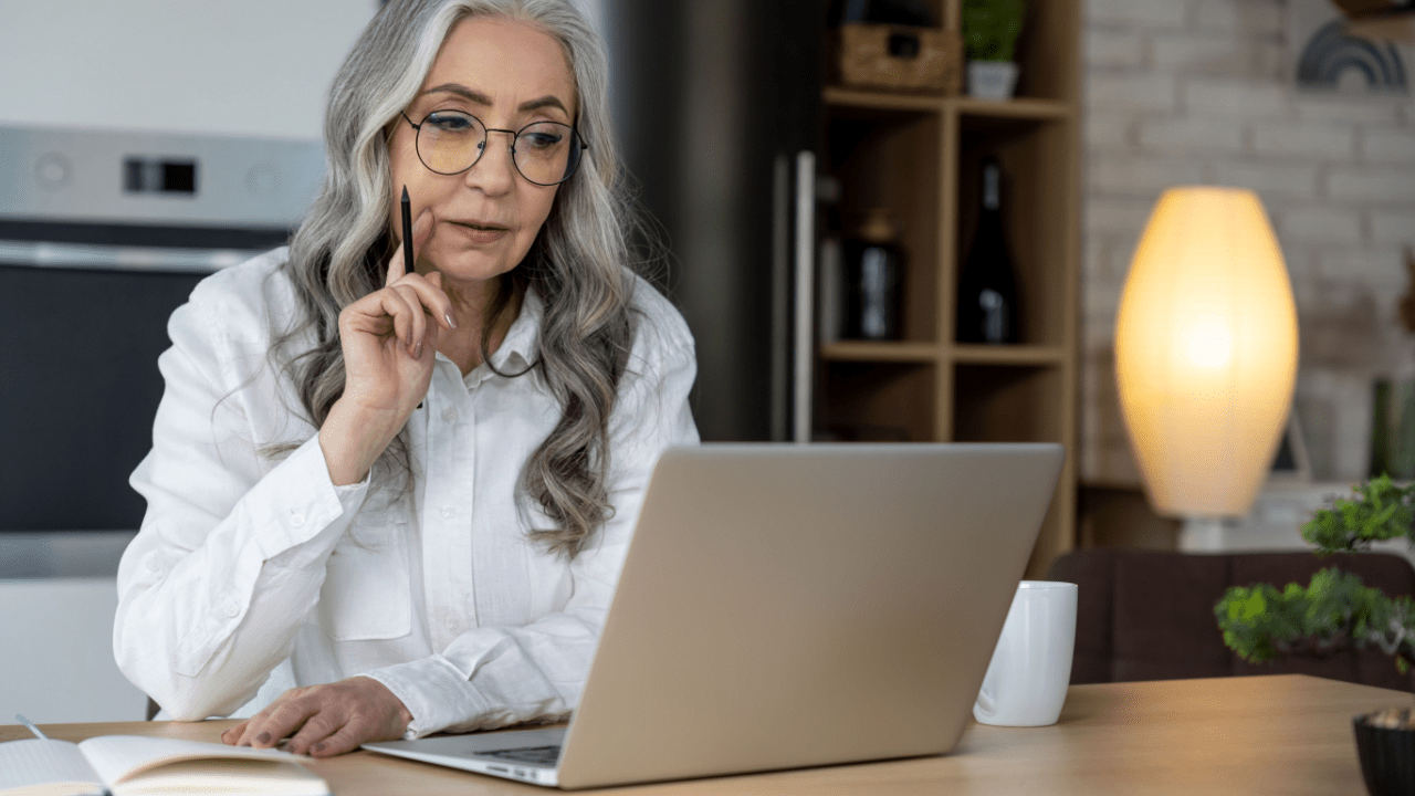 Senior woman researching what is the maximum SSDI payment on laptop computer