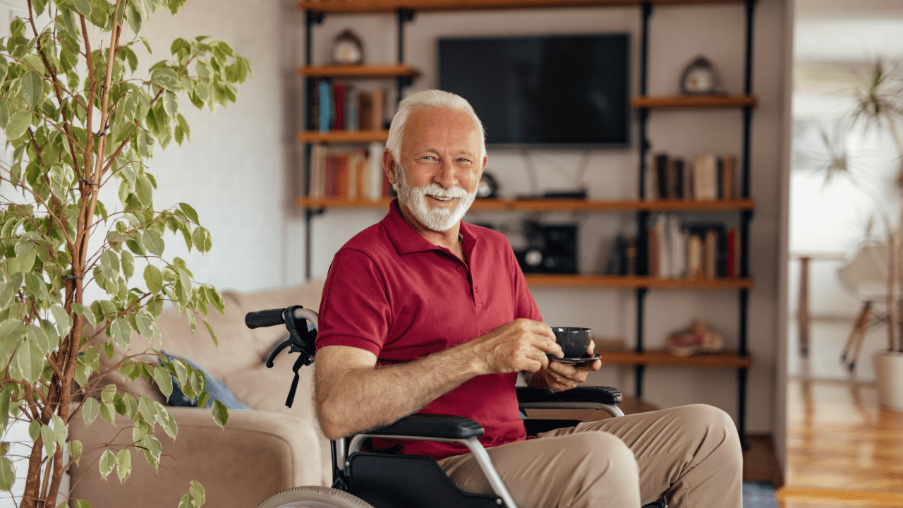 Senior man in wheelchair smiling with coffee, showing what to do when Social Security is not enough to live on