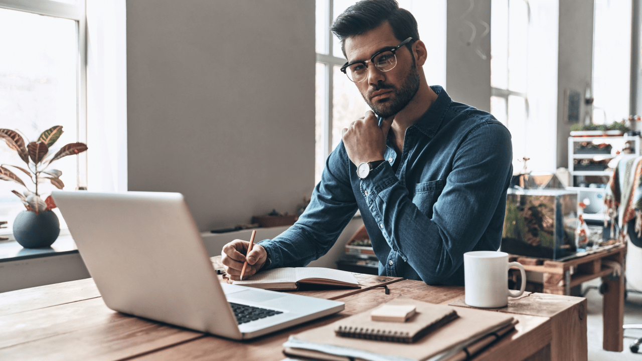 Professional man researching why are SSDI payments higher than SSI at desk with laptop and notes