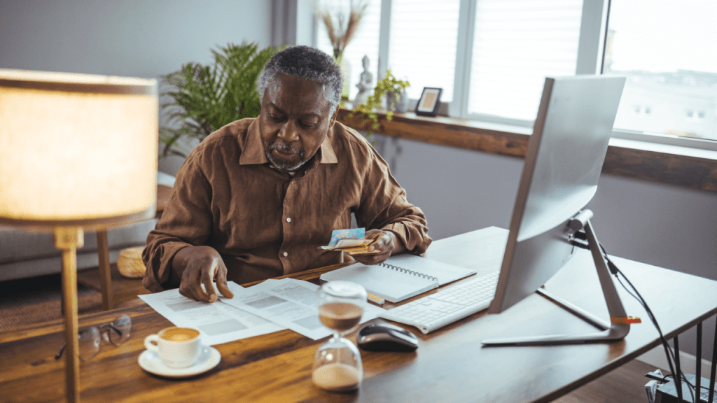 Senior man reviewing Medicare documents and costs while researching do I have to pay for Medicare on SSDI benefits