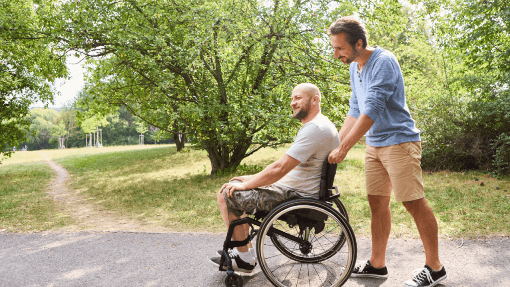 Man in wheelchair with caregiver discussing how much is an adult disability payment