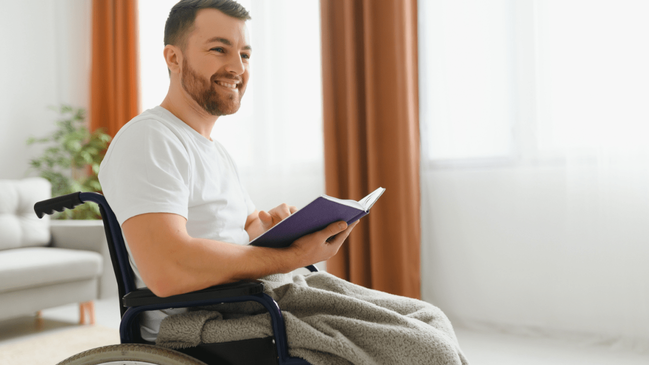 Man in wheelchair reading at home researching benefits - is SSD considered a disability program
