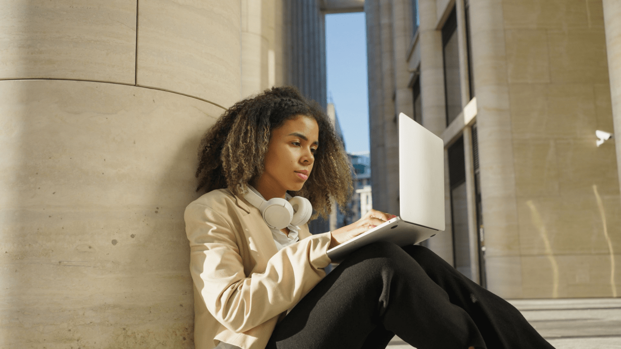 Woman with laptop researching SSDI asset limit requirements while sitting in modern building