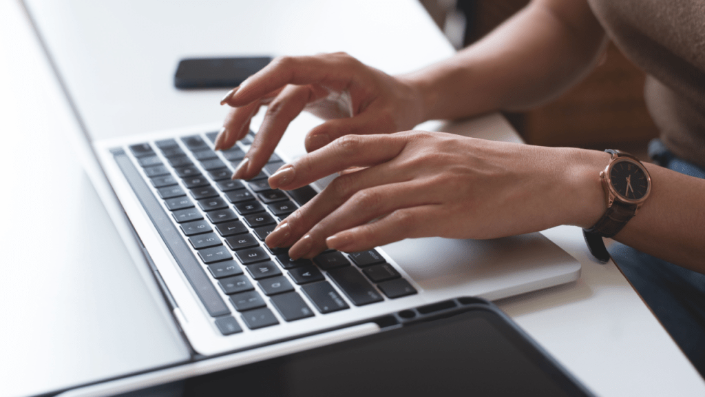 Person with watch typing on laptop researching benefits information, investigating how long can a person stay on social security disability and reviewing eligibility requirements