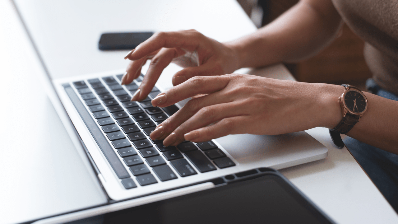 Person with watch typing on laptop researching benefits information, investigating how long can a person stay on social security disability and reviewing eligibility requirements