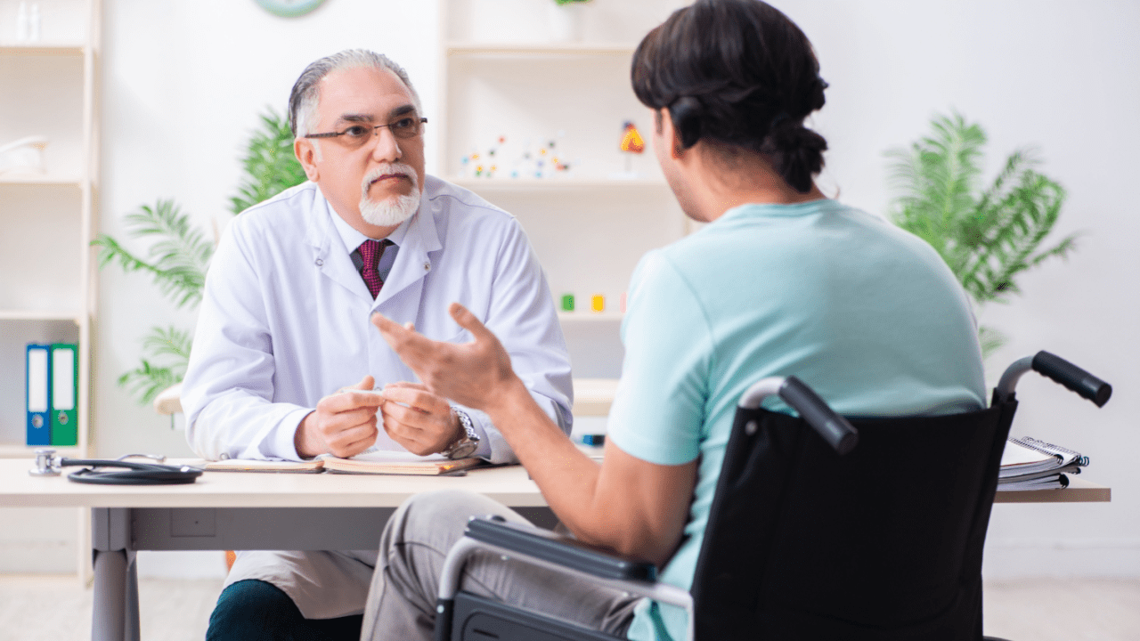 Doctor consulting with wheelchair patient about medical documentation for proving and winning disability cases