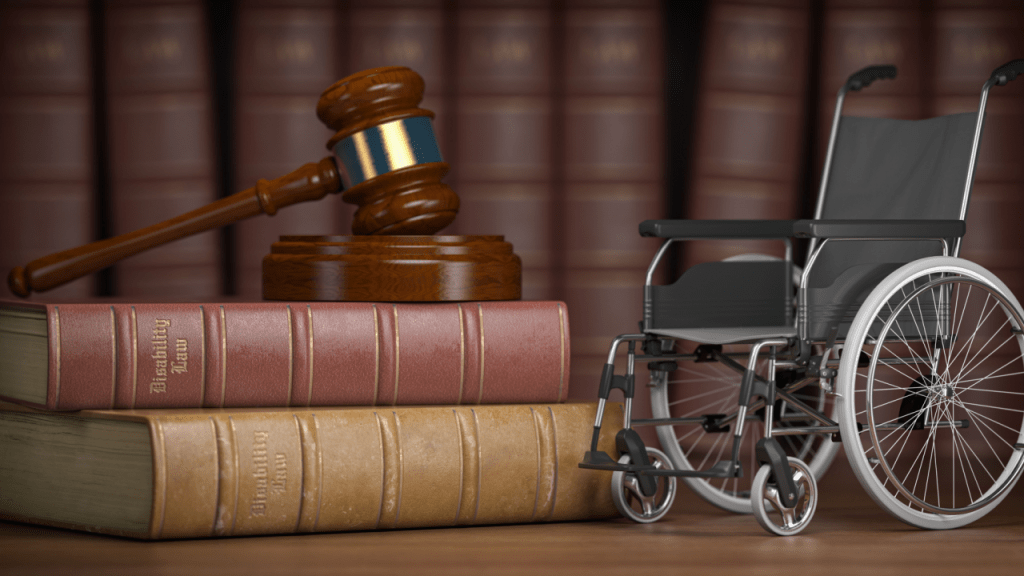 Wooden gavel and law books next to wheelchair representing when should I hire a disability lawyer consultation