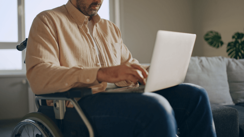 Man in wheelchair researching what illnesses automatically qualify for disability benefits on laptop computer