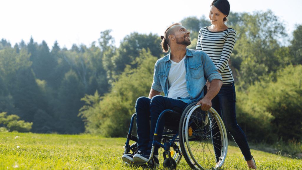 Happy couple in park showing what is considered to be a permanent disability doesn't limit fulfilling relationships and outdoor activities