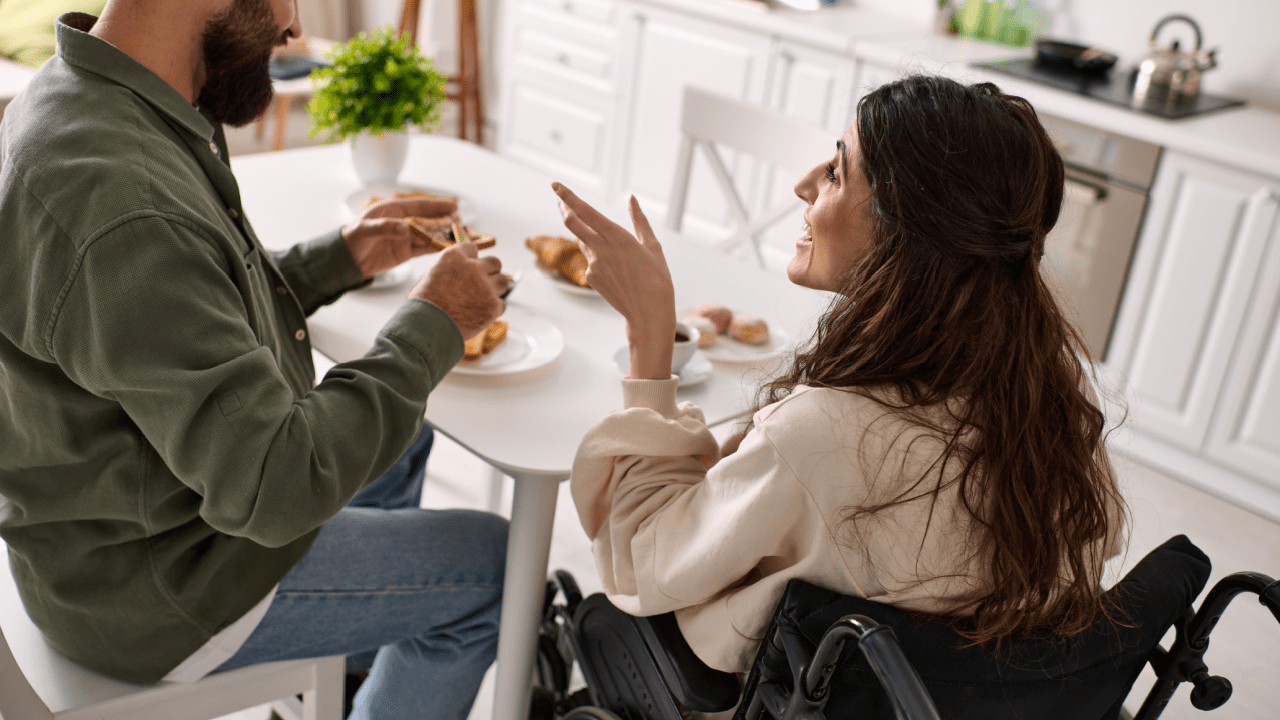 Woman in wheelchair at home discussing how difficult is it to get approved for SSDI with partner