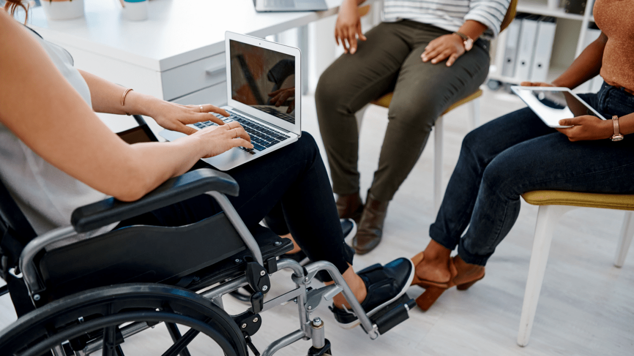 Person in wheelchair using laptop to research is it better to apply for SSDI online or in person