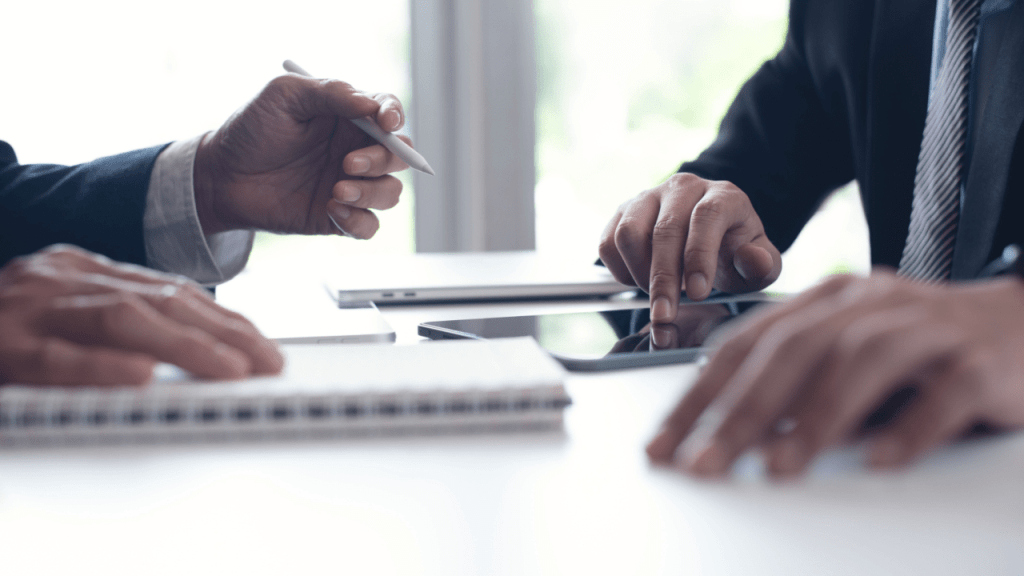 Professional consultation discussing SSDI reconsideration payments back pay and financial impact with client using documents and tablet