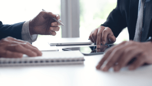 Professional consultation discussing SSDI reconsideration payments back pay and financial impact with client using documents and tablet