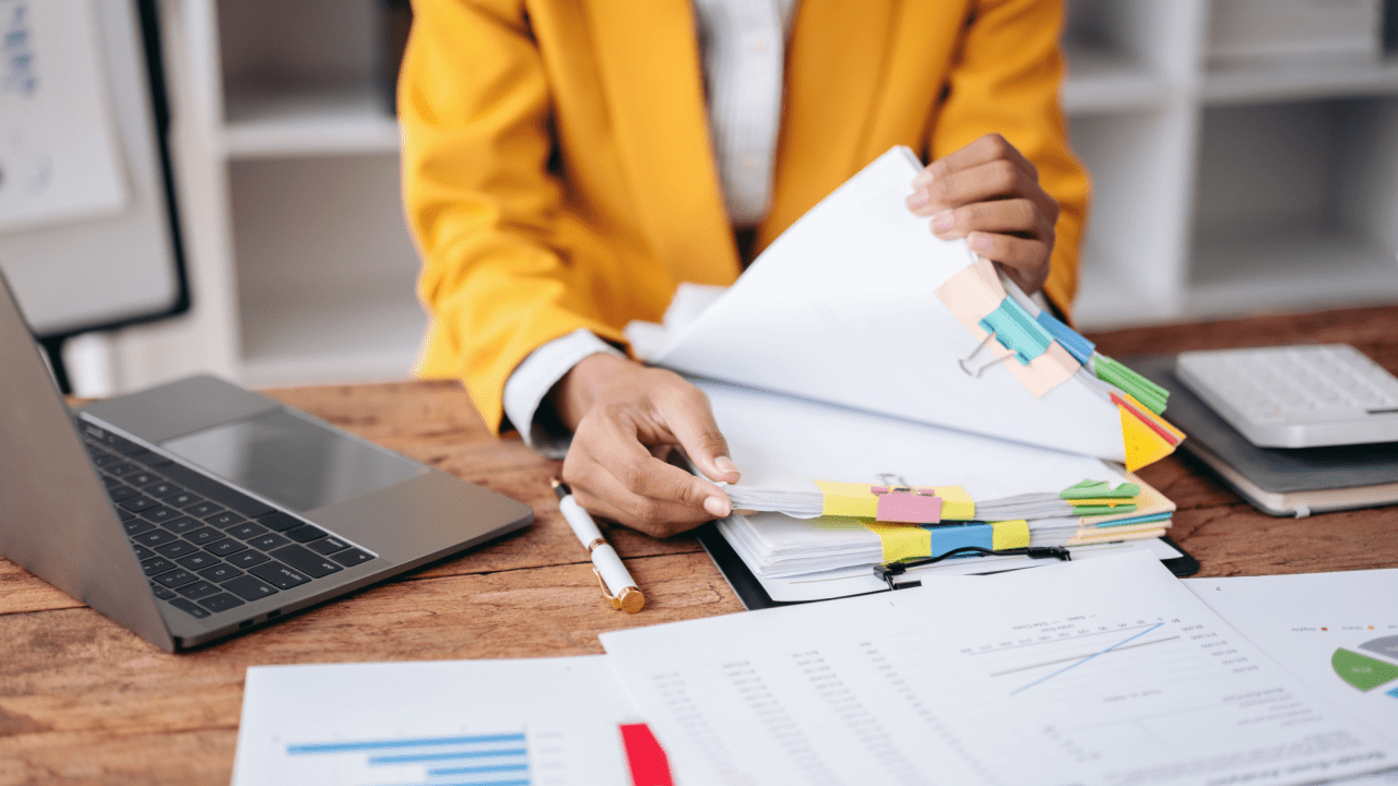 Professional organizing medical documents and paperwork to determine what evidence helps win a disability appeal at desk with laptop