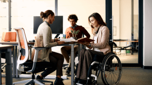Professional woman in wheelchair consulting with disability attorneys about how long does a reconsideration for SSDI take in modern office setting