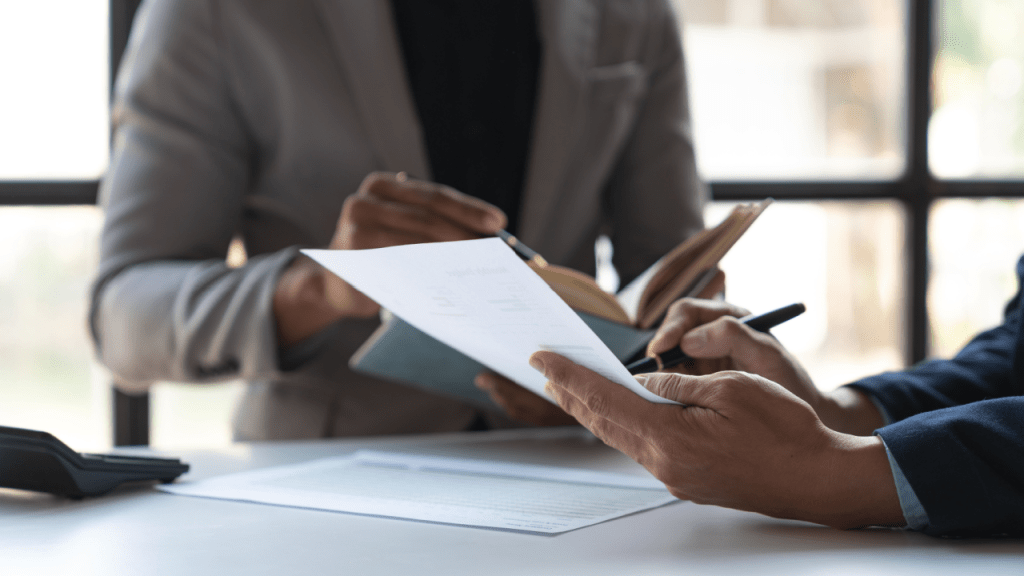 Professional reviewing disability reconsideration reviews documents during consultation meeting