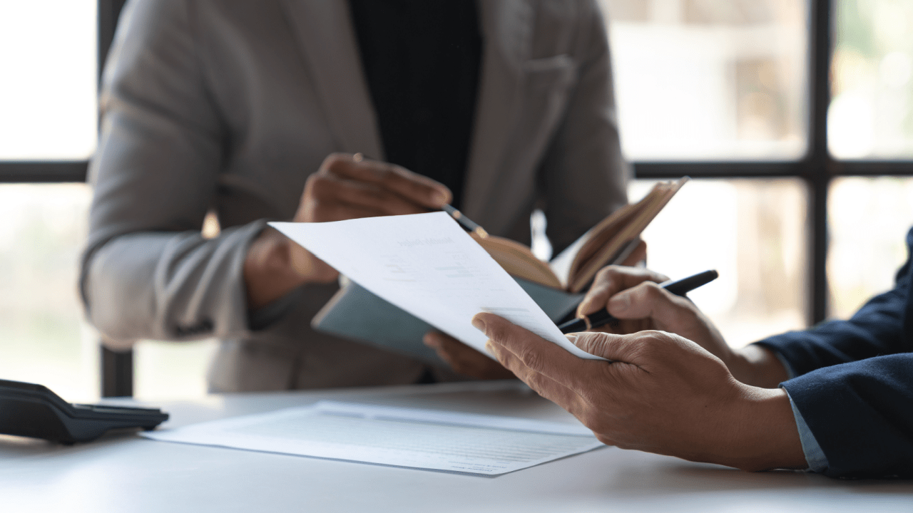 Professional reviewing disability reconsideration reviews documents during consultation meeting