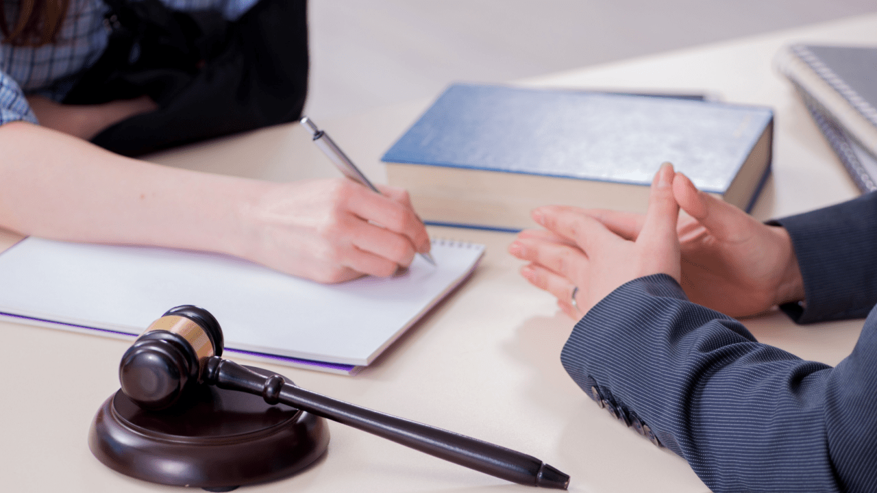 Legal consultation meeting discussing what is a mandatory reconsideration for disability with gavel and law books on desk