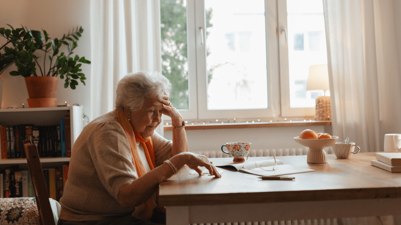 Elderly woman looking stressed while reviewing paperwork, illustrating what problems do people face on social security disability applications