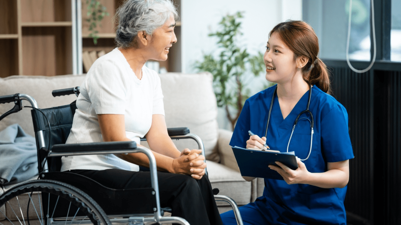 Healthcare professional discussing testing categories and disability types with elderly wheelchair user in home setting