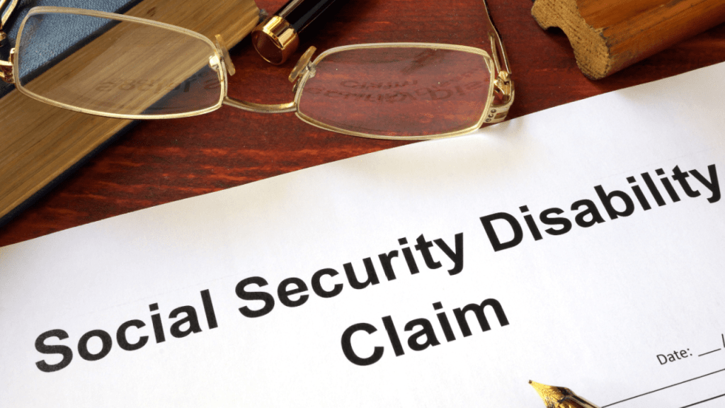 Social Security Disability claim form on desk with glasses showing whether to apply for SSDI online or in person