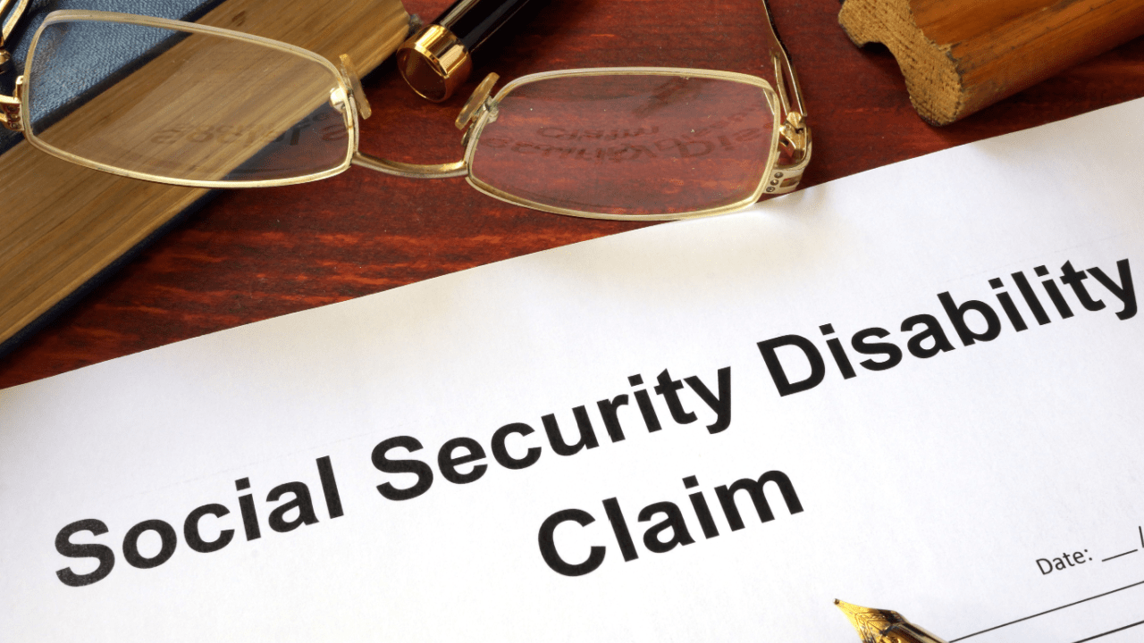Social Security Disability claim form on desk with glasses showing whether to apply for SSDI online or in person