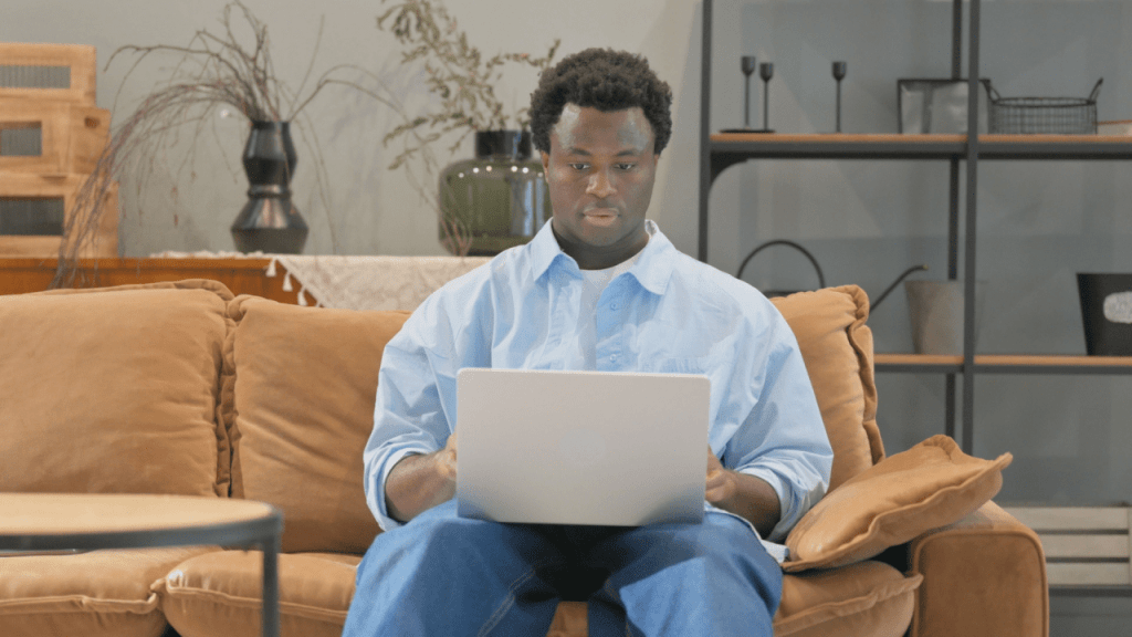 Man on couch with laptop researching what can stop my SSDI benefits