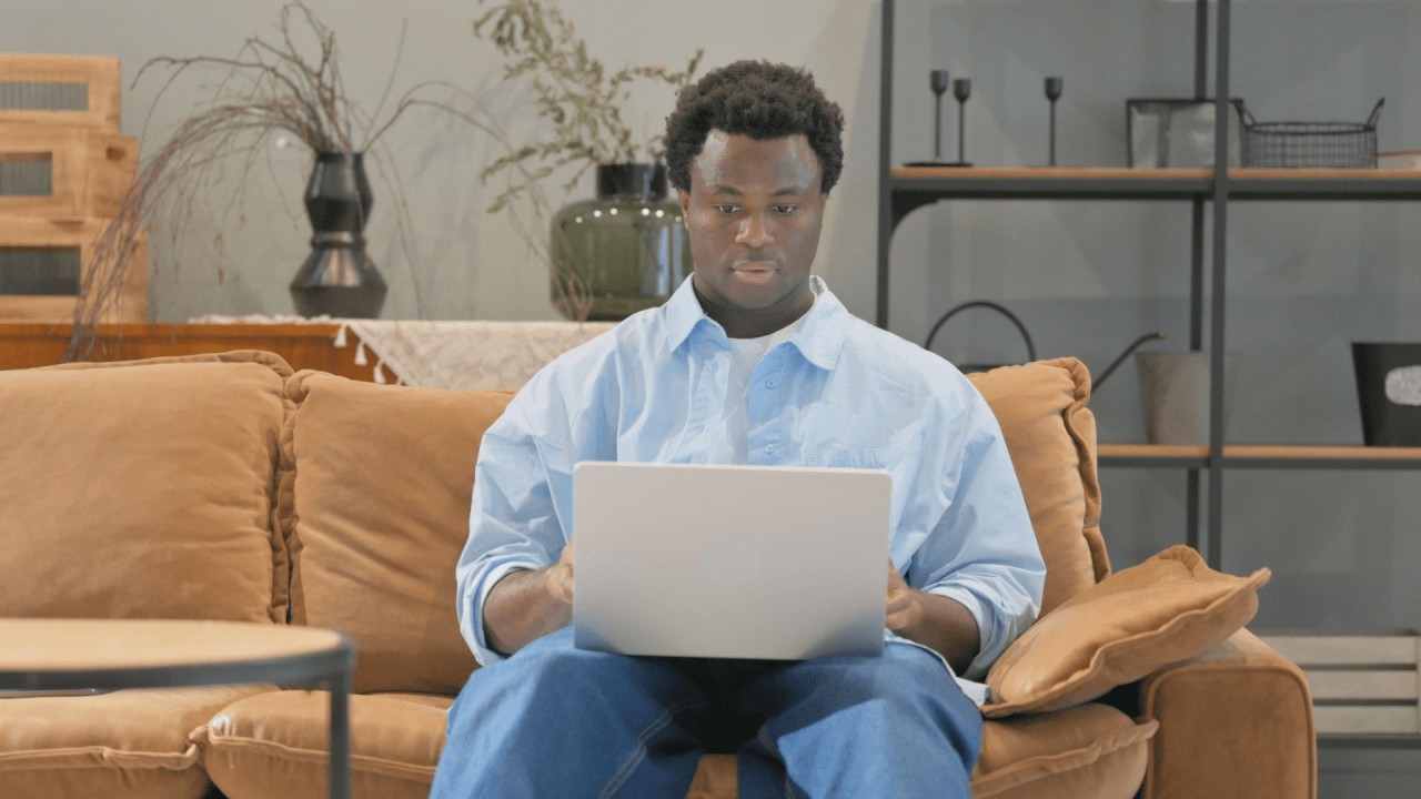 Man on couch with laptop researching what can stop my SSDI benefits