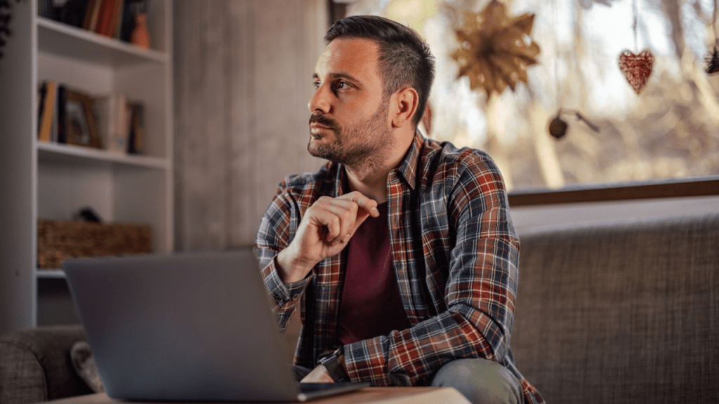 Man at home laptop contemplating what must be reported to SSDI while receiving benefits