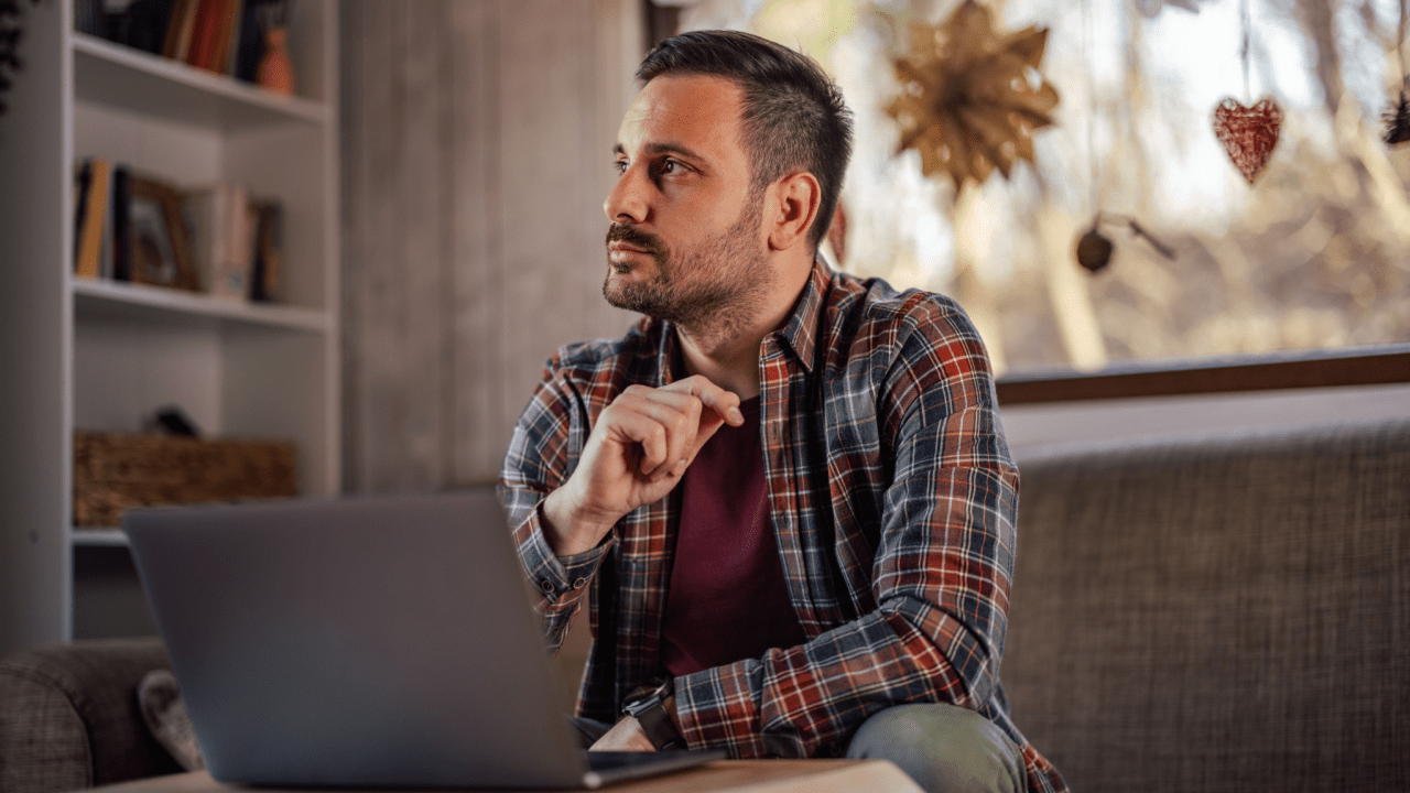 Man at home laptop contemplating what must be reported to SSDI while receiving benefits