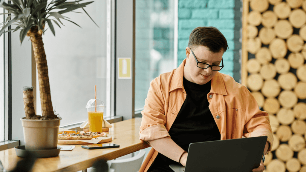 Person with Down syndrome researching what percentage of people get approved for SSDI the first time on laptop