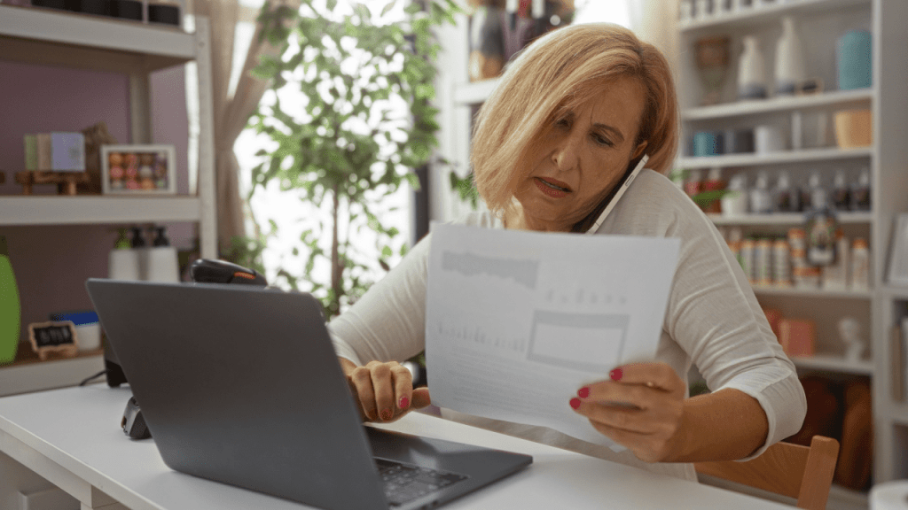 Woman reviewing SSI or SSDI application documents while researching which is faster SSI or SSDI on laptop