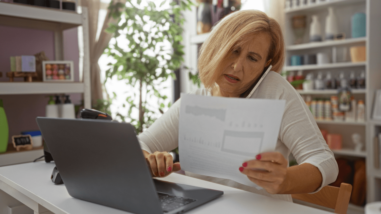 Woman reviewing SSI or SSDI application documents while researching which is faster SSI or SSDI on laptop