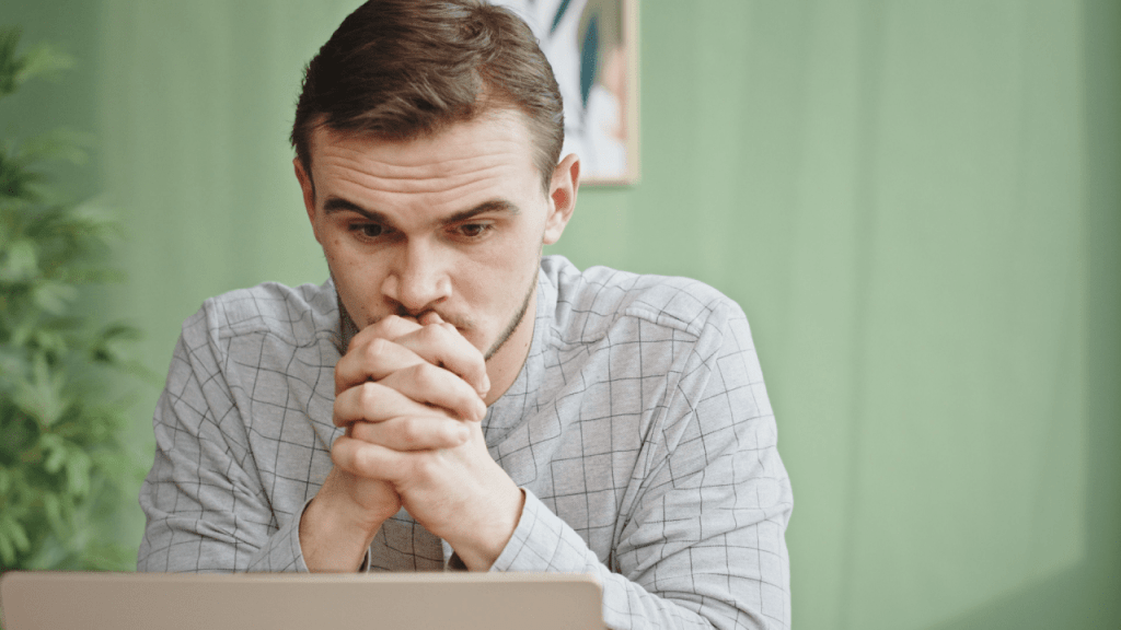 Worried man at laptop concerned about why most people get denied for SSDI benefits