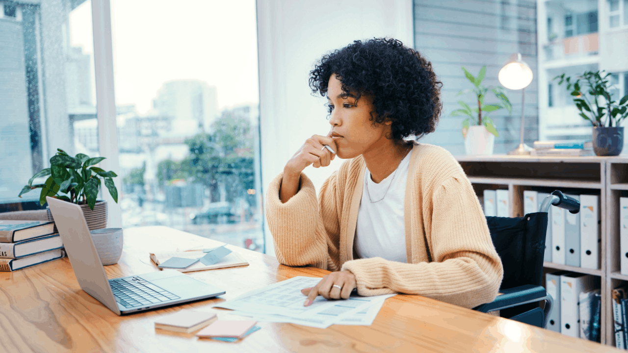 Woman wondering how long does SSDI take to get approved while reviewing disability application documents at home office