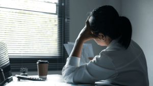 Person experiencing mental health challenges while working, illustrating why many need to learn how to apply for SSDI for mental health benefits