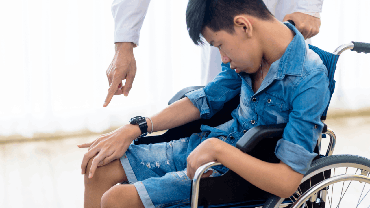 How to apply for SSDI for my child with disabilities - parent assisting child in wheelchair during application process