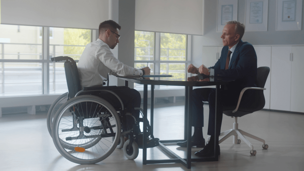 Young man in wheelchair discussing what conditions would qualify you for disability with attorney during consultation