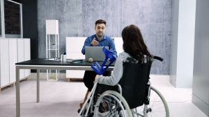 Changes in SSDI appeal outcomes discussion between disability attorney and wheelchair user reviewing case file